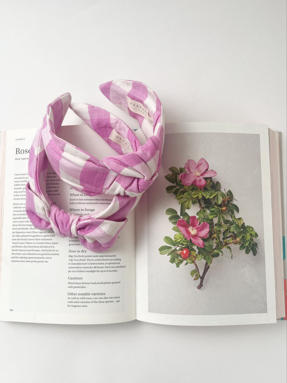 Pink and white patterned headbands on an open book with floral illustration