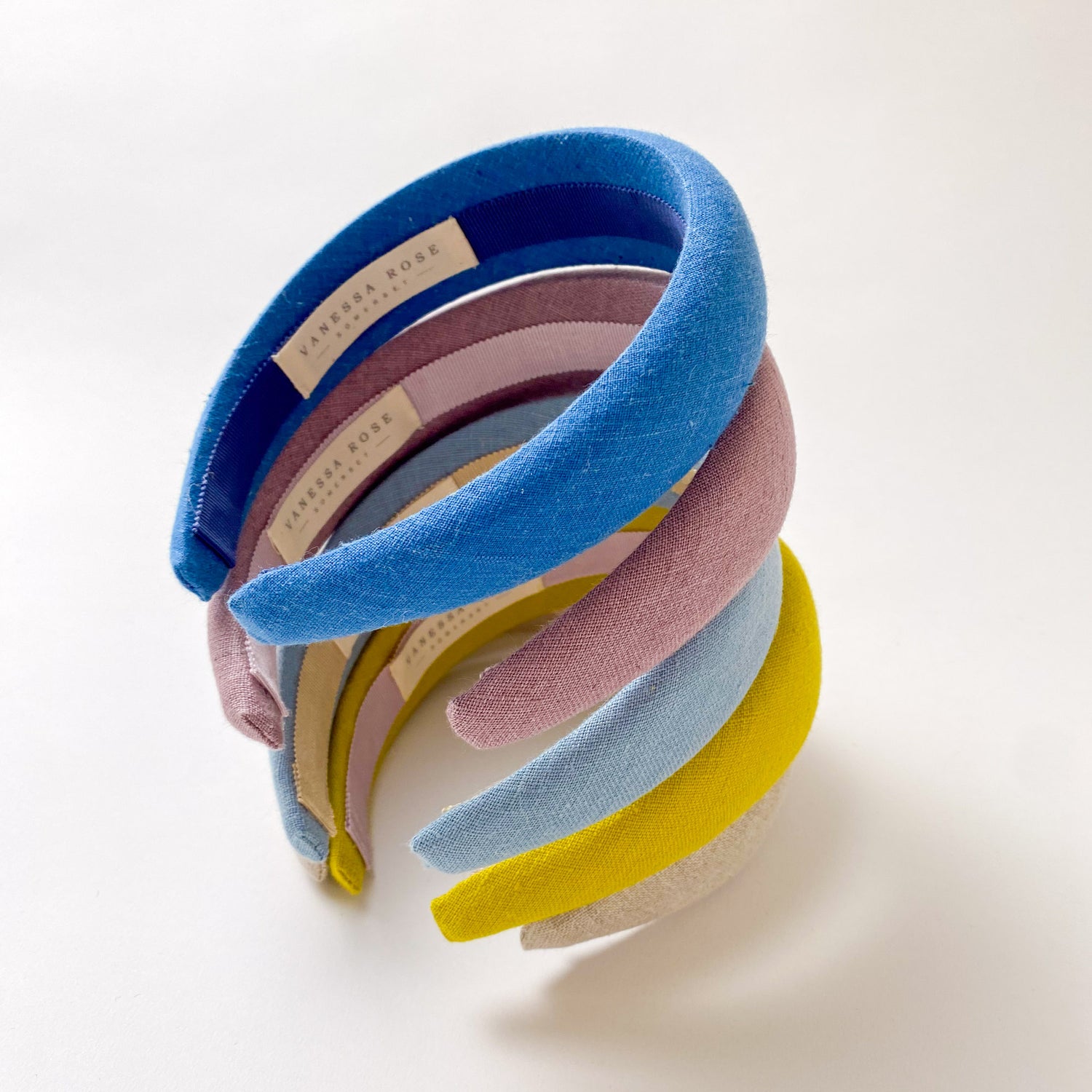 A stack of 5 padded hairbands on a white background